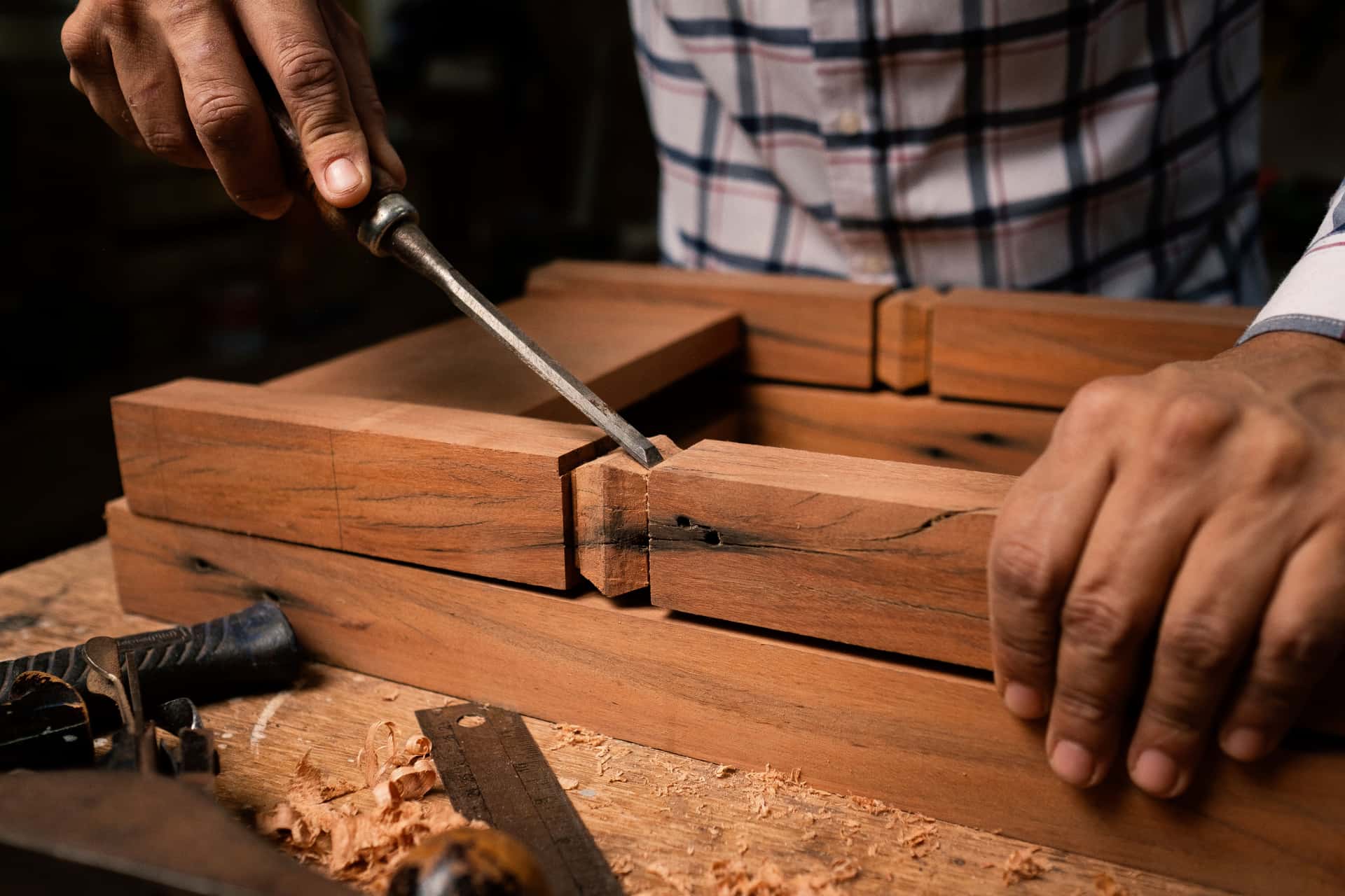 A mid-length panel saw crosscutting a board across a pair of sawhorses