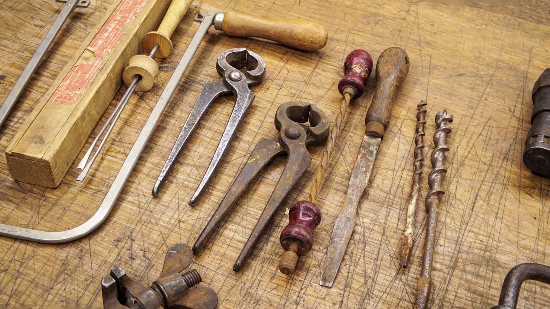 Old rusty hand tools arranged on a weathered surface
