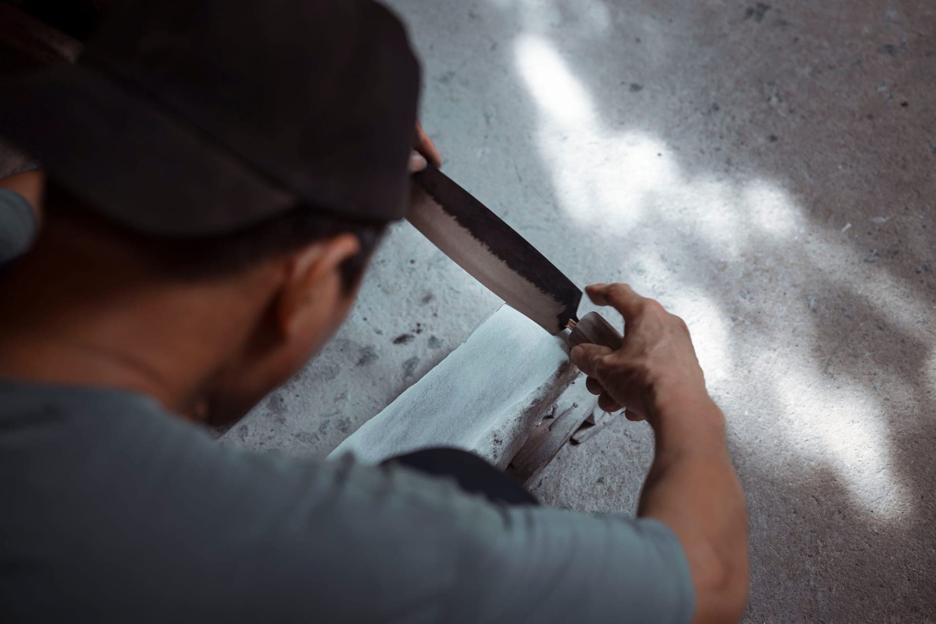 A blade being drawn across a wet sharpening stone